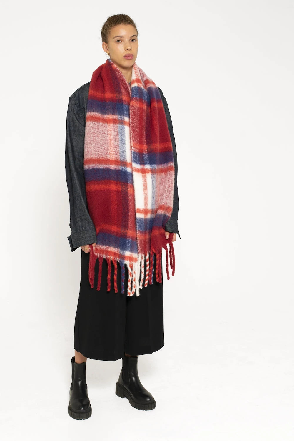 woman wearing extra large red & navy plaid scarf with tassels