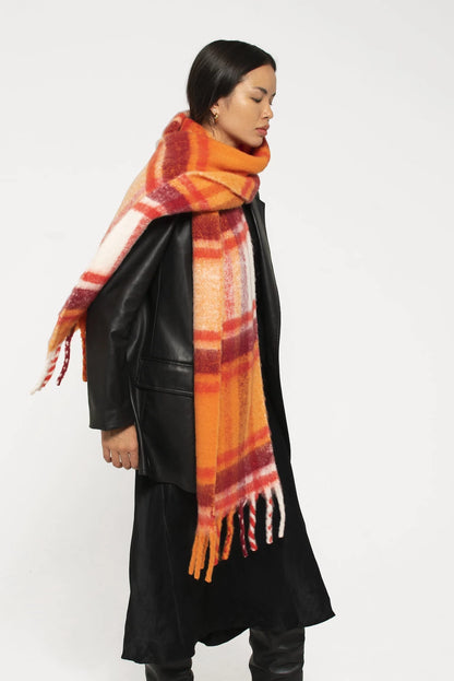 woman wearing oversized orange and red plaid scarf with soft fluffy material