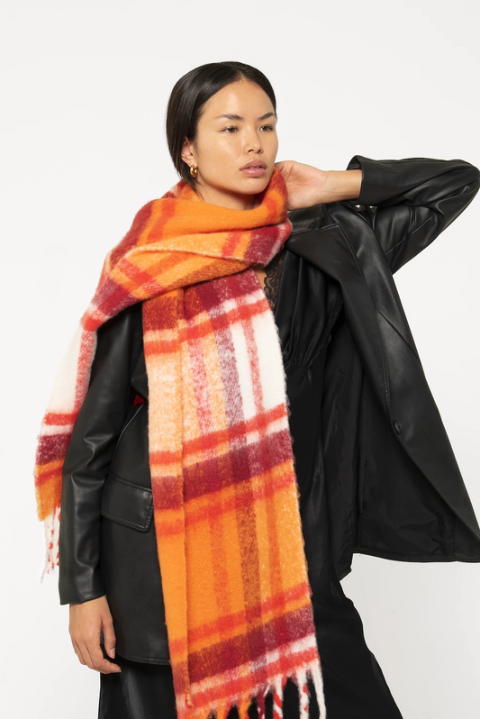 woman wearing oversized orange plaid scarf with soft fluffy material